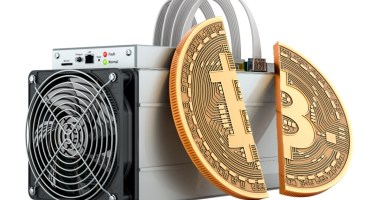 moeda de bitcoin partida ao meio e apoiada em máquina de mineração