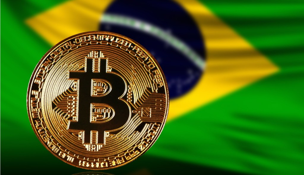 moeda de bitcoin com bandeira do brasil ao fundo (1)