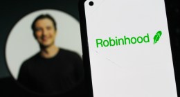Logotipo da Robinhood em um smartphone, com a foto de perfil do CEO Vladimir Tenev ao fundo