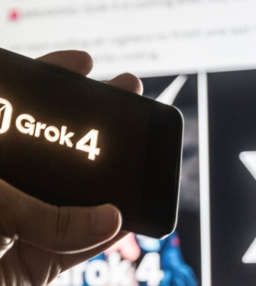 mão segurando celular com logo do Grok 4 IA
