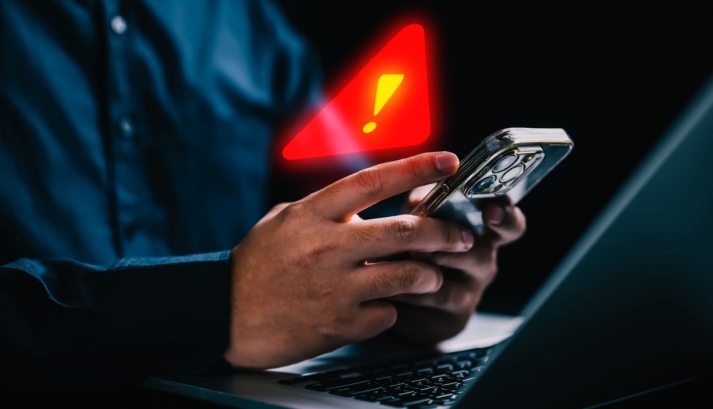 Homem consulta celular que emite red flag