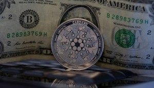 moeda de cardano ADA de frente a nota de 1 dólar